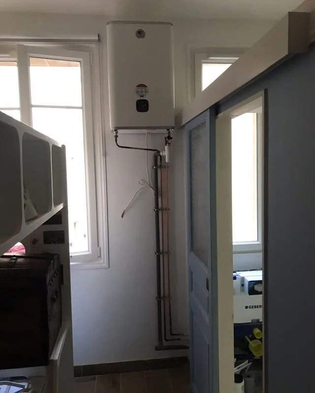 Chauffe-eau plat fixé au mur d’un couloir